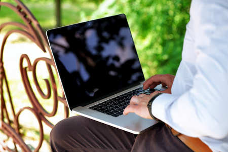 Young man with laptop outdoorsの写真素材