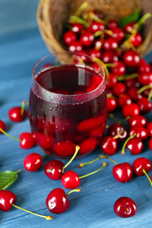 Glass of fresh juice with cherries on wooden table close upの写真素材