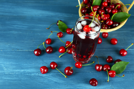 Glass of fresh juice with cherries on wooden table close upの写真素材