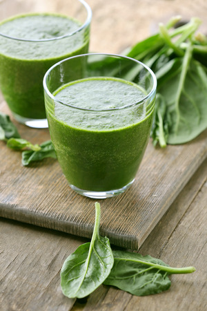 Glasses of spinach juice on wooden table, closeupの写真素材
