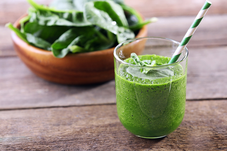 Glass of spinach juice on wooden backgroundの写真素材