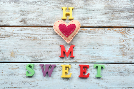 Decorative letters forming words SWEET HOME with heart on wooden backgroundの写真素材
