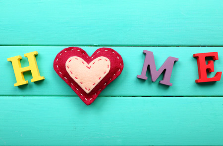 Decorative letters forming word HOME with heart on wooden backgroundの写真素材