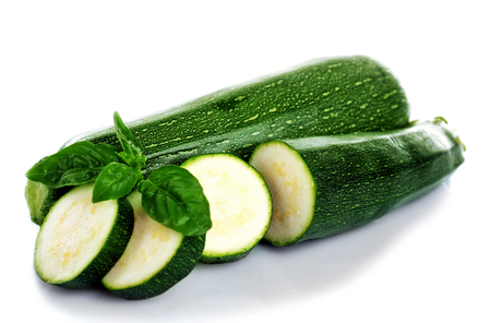 Fresh zucchini with basil isolated on whiteの写真素材