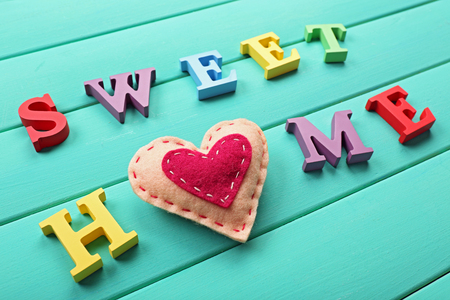 Decorative letters forming words SWEET HOME with heart on wooden backgroundの写真素材