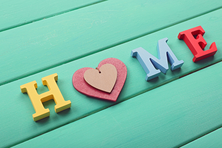 Decorative letters forming word HOME with heart on wooden backgroundの写真素材