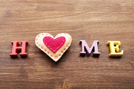 Decorative letters forming word HOME with heart on wooden backgroundの写真素材
