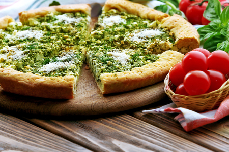 Slices of open pie with spinach and tomato cherry on table close upの写真素材