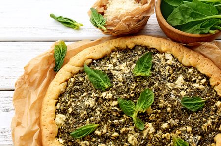 Open pie with spinach on table close upの写真素材