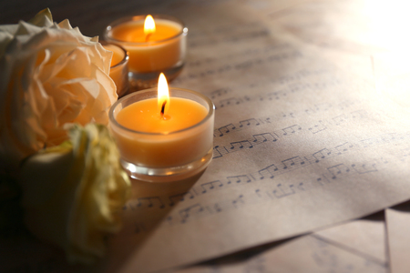 Beautiful rose with candles on music sheets, closeupの写真素材