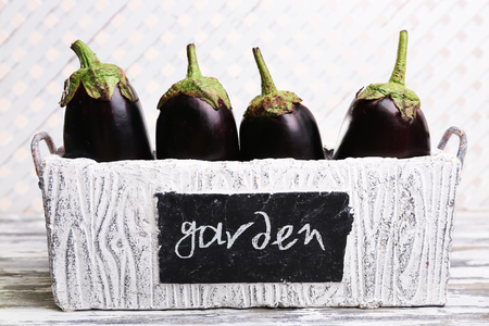 Fresh eggplant in box on wooden backgroundの写真素材