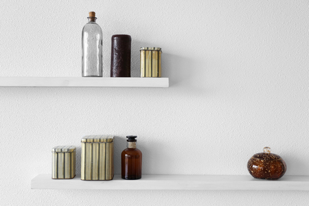 Decorative vases on wooden shelf  on white wallpaper backgroundの写真素材
