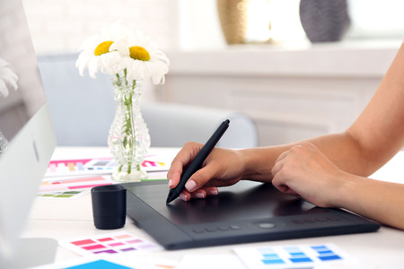 Artist drawing on graphic tablet in officeの写真素材