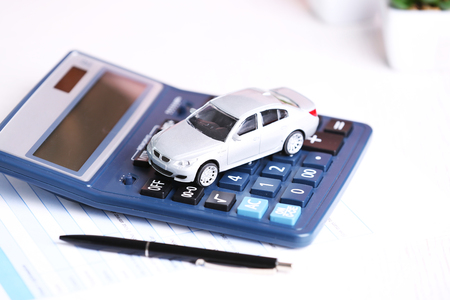 Toy car, documents and calculator on table. Car insurance conceptの写真素材