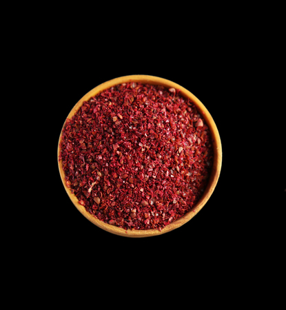 Sumac in wooden bowl, isolated on blackの写真素材