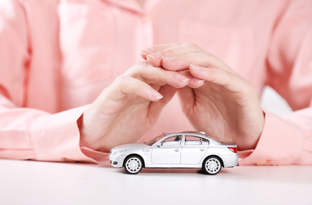 Hands and toy car. Protection of car conceptの写真素材