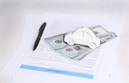 Toy car, money and documents on table. Car insurance conceptの写真素材