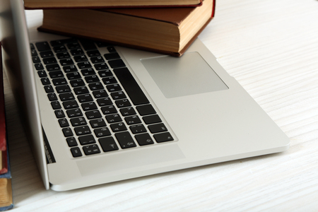 Laptop with book on table close upの写真素材