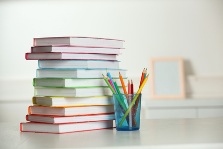 Colorful books and pencil on table in roomの写真素材