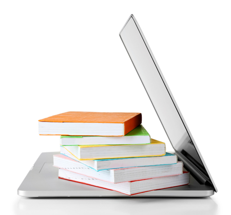 Stack of books with laptop isolated on whiteの写真素材