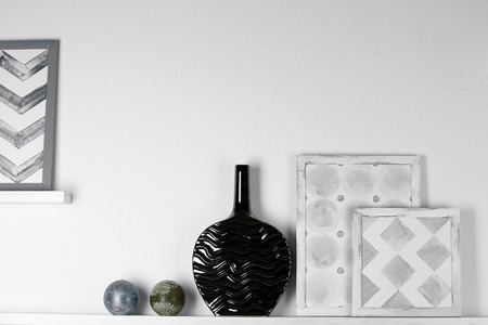 Modern vase with picture on shelf in room