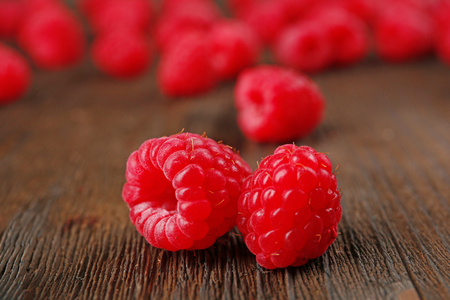 Fresh red raspberries on wooden table, closeup
