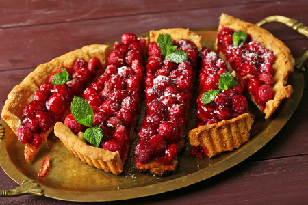 Tart with raspberries on tray, on wooden backgroundの写真素材