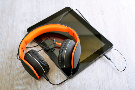 Headphones with tablet on wooden table close upの写真素材