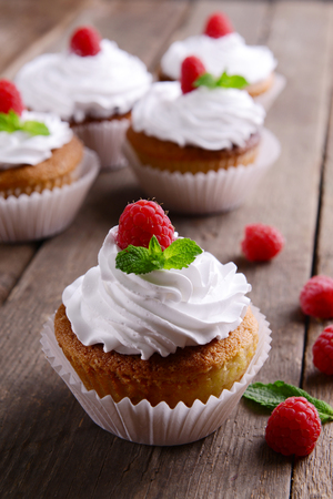 Delicious cupcakes with berries and fresh mint on wooden table close upの写真素材