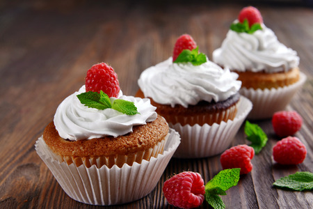 Delicious cupcakes with berries and fresh mint on wooden table close upの写真素材