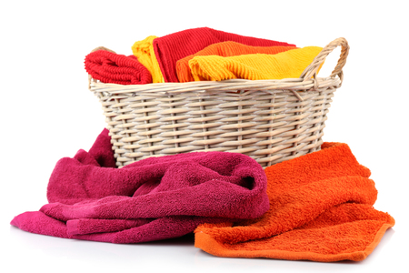 Colorful towels in basket isolated on whiteの写真素材