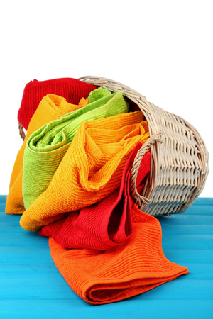 Colorful towels in basket on light backgroundの写真素材