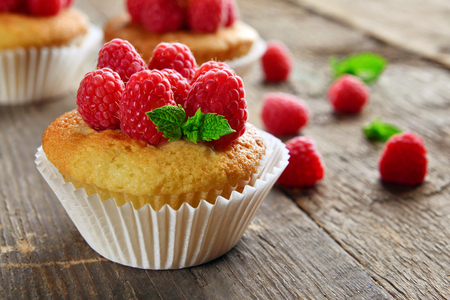 Delicious cupcakes with berries and fresh mint on wooden table close upの写真素材