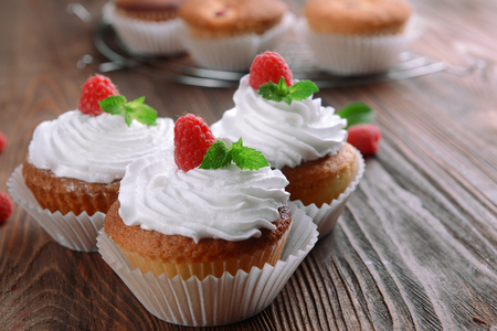Delicious cupcakes with berries and fresh mint on wooden table close upの写真素材