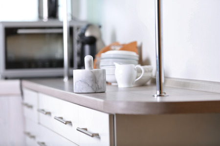 Cook hands with mortar with herbs on bright backgroundの写真素材