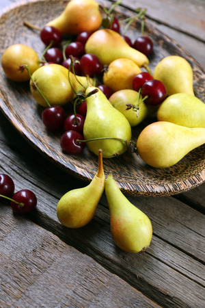 Ripe pears and cherries on wooden table close upの写真素材