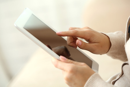 Female hand holding PC tablet on home interior background