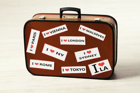 Suitcase with stickers on floor in room