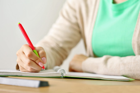 Female hand writing in notebook, close-upの写真素材