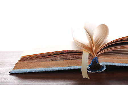 Pages of book curved into heart shape,  on white backgroundの写真素材