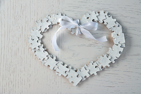 Puzzle made heart shape on light background