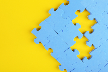 Puzzle pieces on yellow backgroundの写真素材