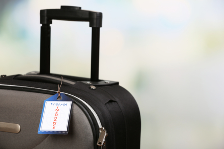 Suitcase with TRAVEL INSURANCE label, closeupの写真素材
