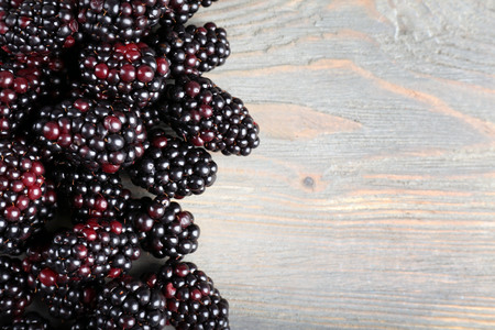 Heap of sweet blackberries on wooden table close upの写真素材