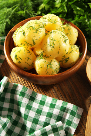 Boiled potatoes with greens in bowl on table close upの写真素材
