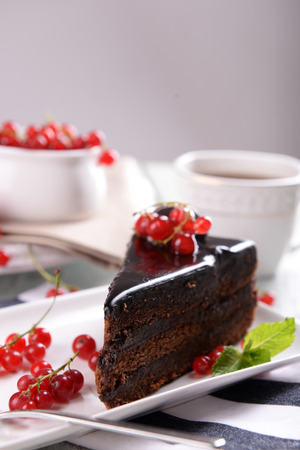 Tasty chocolate cake with berries and cup of tea on table close upの写真素材