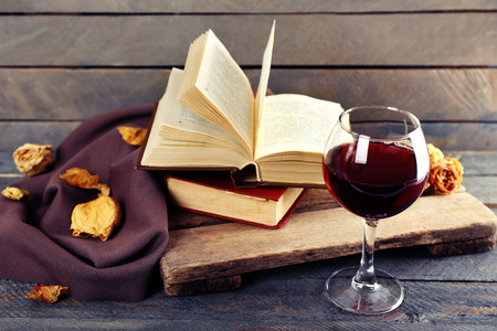 Beautiful composition with glass of wine with old books on table close upの写真素材