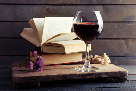 Beautiful composition with glass of wine with old books on table close upの写真素材
