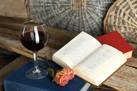 Beautiful composition with glass of wine with old books on table close upの写真素材