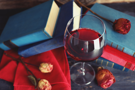 Beautiful composition with glass of wine with old books on table close upの写真素材